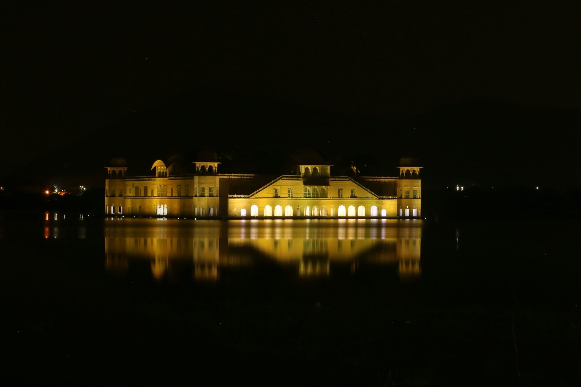 Jal Mahal palace in Jaipur lit up at night and reflected in Man Sagar Lake