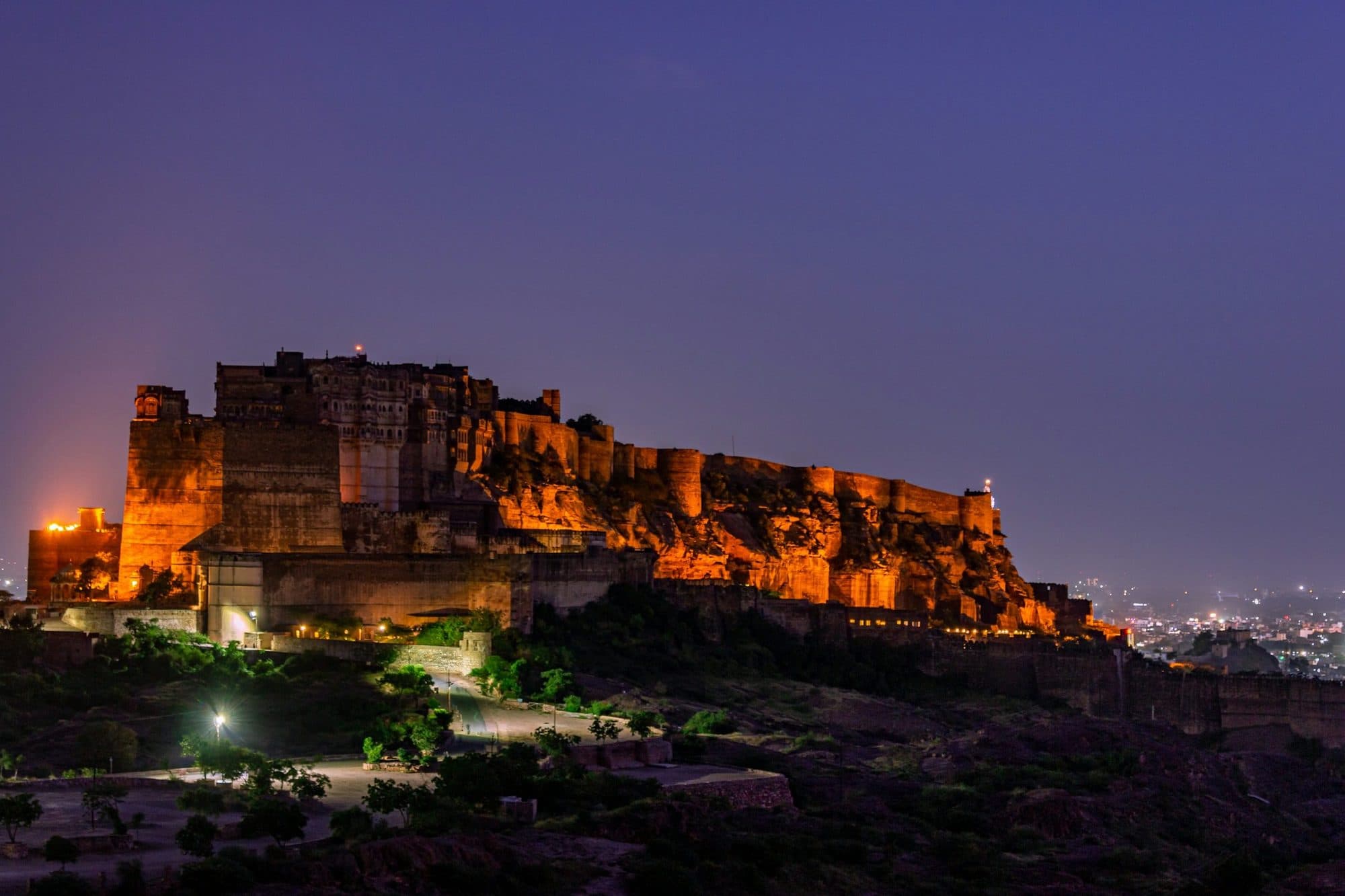 Mehrangarh Fort in Jodhpur floodlit at dusk under a violet sky